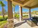 Covered porch with stone columns and wicker furniture at 728 Costa Ln, Debary, FL 32713