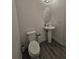 Powder room with pedestal sink, toilet and gray flooring at 728 Costa Ln, Debary, FL 32713