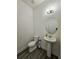 Powder room with pedestal sink, toilet and gray flooring at 728 Costa Ln, Debary, FL 32713