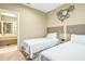 Bright bedroom with two twin beds, ensuite bathroom access, and unique wall decor at 3062 Rockefeller Way, Kissimmee, FL 34747