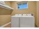 Convenient laundry room with washer, dryer, and overhead shelving at 3062 Rockefeller Way, Kissimmee, FL 34747