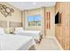 Spacious bedroom featuring two twin beds, large window, and wood-paneled accent wall at 3062 Rockefeller Way, Kissimmee, FL 34747