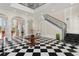 Elegant entry hall with checkerboard floor, grand staircase, and high ceilings at 5507 Worsham Court, Windermere, FL 34786