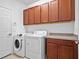 Laundry room with washer, dryer, and ample cabinetry at 283 Silver Maple Rd, Groveland, FL 34736