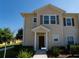 Two-story townhome with light beige exterior and dark brown door at 8947 Shine Dr, Kissimmee, FL 34747