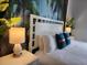 Bedroom with a white headboard, tropical mural, and nightstands at 8947 Shine Dr, Kissimmee, FL 34747