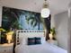 Main bedroom with a tropical-themed wall mural and king-size bed at 8947 Shine Dr, Kissimmee, FL 34747