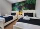 Two twin beds with white frames and tropical leaf mural at 8947 Shine Dr, Kissimmee, FL 34747