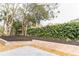 Landscaped backyard with trees, retaining walls, and a patio area at 2612 Lafayette Ave, Winter Park, FL 32789