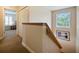 Upstairs hallway with carpet, wood railing, and a view to a bedroom at 2909 Calabria Ave, Davenport, FL 33837