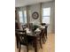 Dining room with a dark wood table, six chairs, and large windows at 370 Lasso Dr, Kissimmee, FL 34747