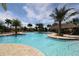 Large resort-style pool with palm trees and thatch umbrellas at 1165 Trappers Trail Loop, Davenport, FL 33896