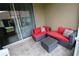 Relaxing lanai with wicker furniture and red cushions at 1165 Trappers Trail Loop, Davenport, FL 33896