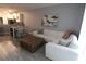 Living room with sectional sofa and ottoman, open to kitchen at 1165 Trappers Trail Loop, Davenport, FL 33896