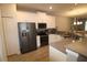 Modern kitchen with white cabinets, gray countertops, and stainless steel appliances at 1165 Trappers Trail Loop, Davenport, FL 33896