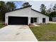 Modern home exterior with a black and white color scheme and landscaped yard at 14759 Sw 43Rd Terrace Rd, Ocala, FL 34473