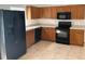 Kitchen features dark appliances and wood cabinets at 4400 Creeks Run Blvd, Kissimmee, FL 34746