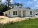 Single story home with light colored siding, gray roof, and landscaping at 1328 Burnley Ct, Kissimmee, FL 34758