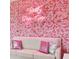 Living room features a pink rose wall and comfy seating at 3191 Paradox Cir # 202, Kissimmee, FL 34746