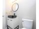 Modern bathroom with black vessel sink, white vanity, and a round mirror at 2920 Pecan Ave, Leesburg, FL 34748