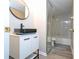 Bathroom with modern vanity, round mirror and tub shower combo at 2920 Pecan Ave, Leesburg, FL 34748