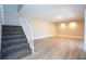 Spacious living room with light wood-look flooring and carpeted stairs at 2920 Pecan Ave, Leesburg, FL 34748