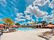 Inviting community pool with lounge chairs and palm trees under a sunny sky at 4289 Lana Ave, Davenport, FL 33897