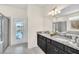 Double vanity bathroom with granite countertop, large mirror, and pool view at 4289 Lana Ave, Davenport, FL 33897