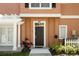 Townhouse front entrance with a dark brown door and landscaping at 2208 San Vittorino Cir # 101, Kissimmee, FL 34741