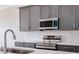 Modern kitchen with stainless steel appliances and white quartz countertops at 10625 Summit Lakes Ln, Clermont, FL 34711