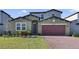 Two-story house with a red door and brick driveway at 5692 Camilla St, St Cloud, FL 34771