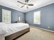 Blue-walled bedroom featuring a large bed, window, and ceiling fan at 310 Vista Oak Dr, Longwood, FL 32779
