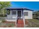 A charming white house with a blue trim, covered porch, and a brick pathway at 1604 Peach Ave, Sanford, FL 32771