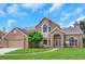 Two-story brick home with a landscaped lawn and attached garage at 2111 Turnberry Dr, Oviedo, FL 32765