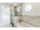 Modern bathroom with glass shower, freestanding tub, and a round window at 2111 Turnberry Dr, Oviedo, FL 32765