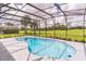 Inviting kidney-shaped pool with screened enclosure, overlooking a lush green landscape at 2111 Turnberry Dr, Oviedo, FL 32765