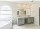 Elegant bathroom with double vanity, soaking tub, and large mirror at 2111 Turnberry Dr, Oviedo, FL 32765
