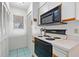 Well-equipped kitchen with stove, microwave, and ample storage at 466 Bouchelle Dr # 202, New Smyrna Beach, FL 32169
