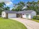 White house with a stone facade, a two-car garage, and a well-maintained lawn at 3130 Willow Oak Dr, Edgewater, FL 32141