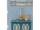 Teal cabinet with decorative vase and artwork at 770 Pebble Beach Dr, Davenport, FL 33896