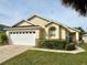 House exterior featuring a white garage door and landscaping at 2555 Oneida Loop, Kissimmee, FL 34747