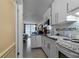 Small kitchen with white cabinets, granite counters, and ocean view at 701 S Atlantic Ave # 508, Daytona Beach, FL 32118