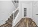 View of carpeted staircase with white railing and wood-look flooring in a bright foyer at 1538 Echo Lake Ct, Orlando, FL 32828