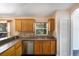 Kitchen with wood cabinets, stainless steel dishwasher, and double sink at 221 Rosa Ave, Oviedo, FL 32765