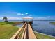 Wooden dock extending into lake with gazebo at 2205 Cypress Cove Dr, Tavares, FL 32778