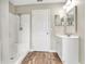 Updated bathroom with white vanity, shower/tub combo and wood-look floors at 10 Locust Run Crse, Ocala, FL 34472
