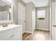 Bathroom with white vanity, window, and wood-look flooring at 10 Locust Run Crse, Ocala, FL 34472