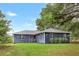 Newly remodeled home featuring a dark blue exterior and a well-manicured lawn at 10 Locust Run Crse, Ocala, FL 34472