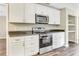Modern kitchen with white cabinets, stainless steel appliances, and granite countertops at 10 Locust Run Crse, Ocala, FL 34472