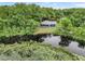 House nestled on a waterfront lot, lush trees surround the property at 10 Locust Run Crse, Ocala, FL 34472